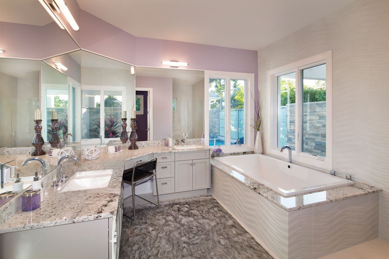 A bathroom with two sinks, a tub, and a large mirror.