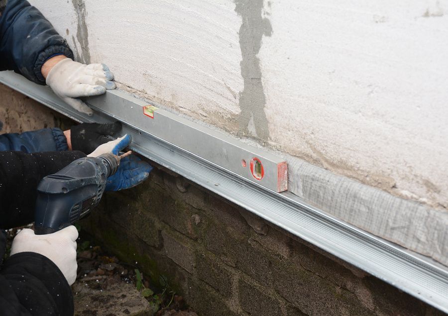 a person with a pair of gloves on working on a window