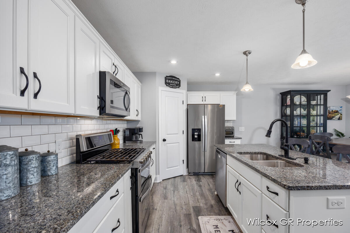 7849 High Knoll Drive - kitchen with white cabinets , granite counter tops , stainless steel appliances and a large island.