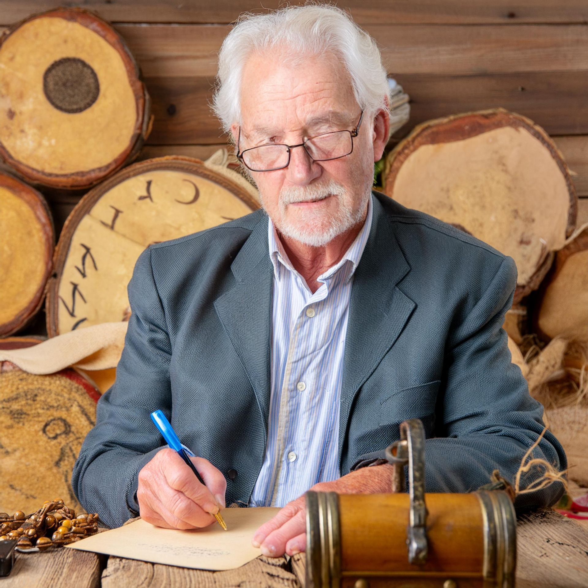 Ein Mann mit Brille schreibt auf ein Stück Papier sein Testament