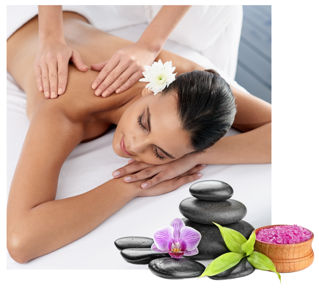 Spa massage with woman lying face down, flower in hair, and stacked black stones with orchid and candles