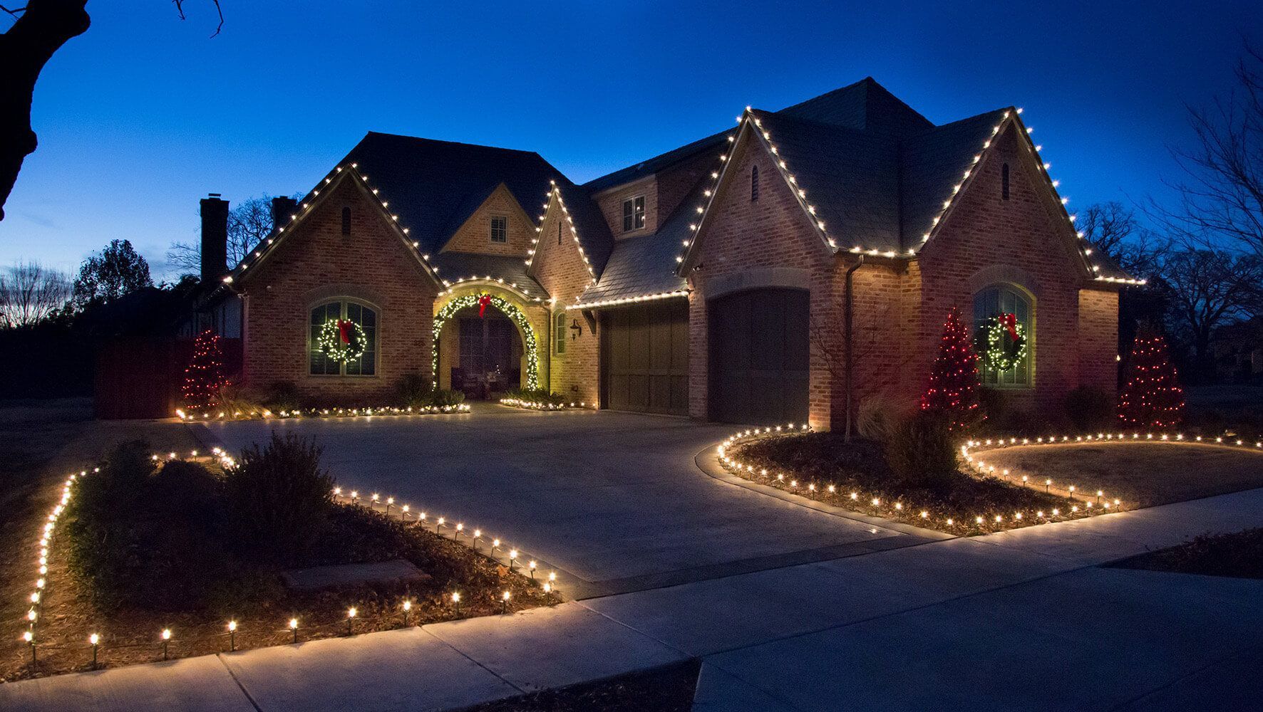 A brick house decorated with christmas lights at night