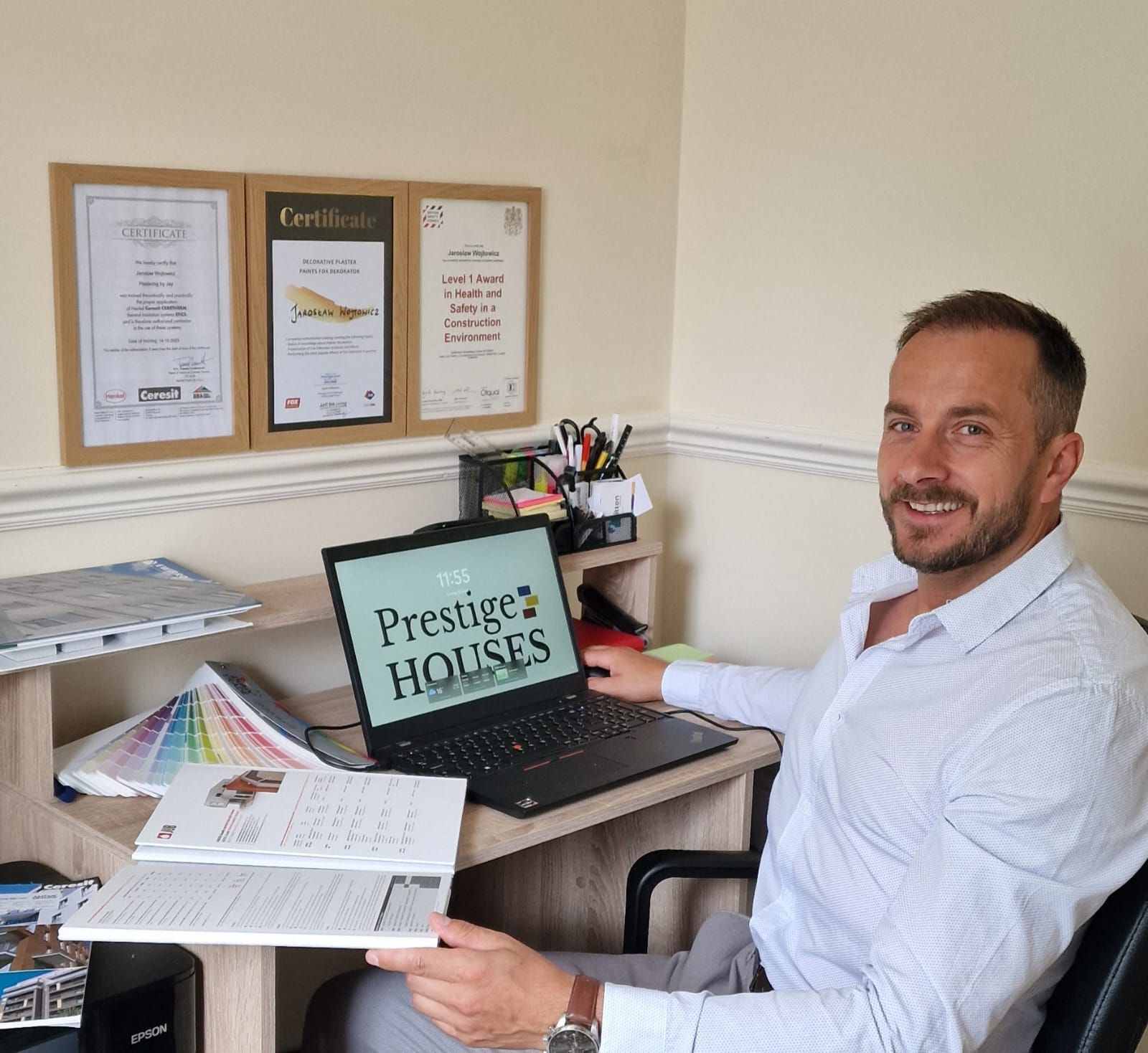 Jay Wojtowicz is sitting at a desk with a laptop that says prestige houses