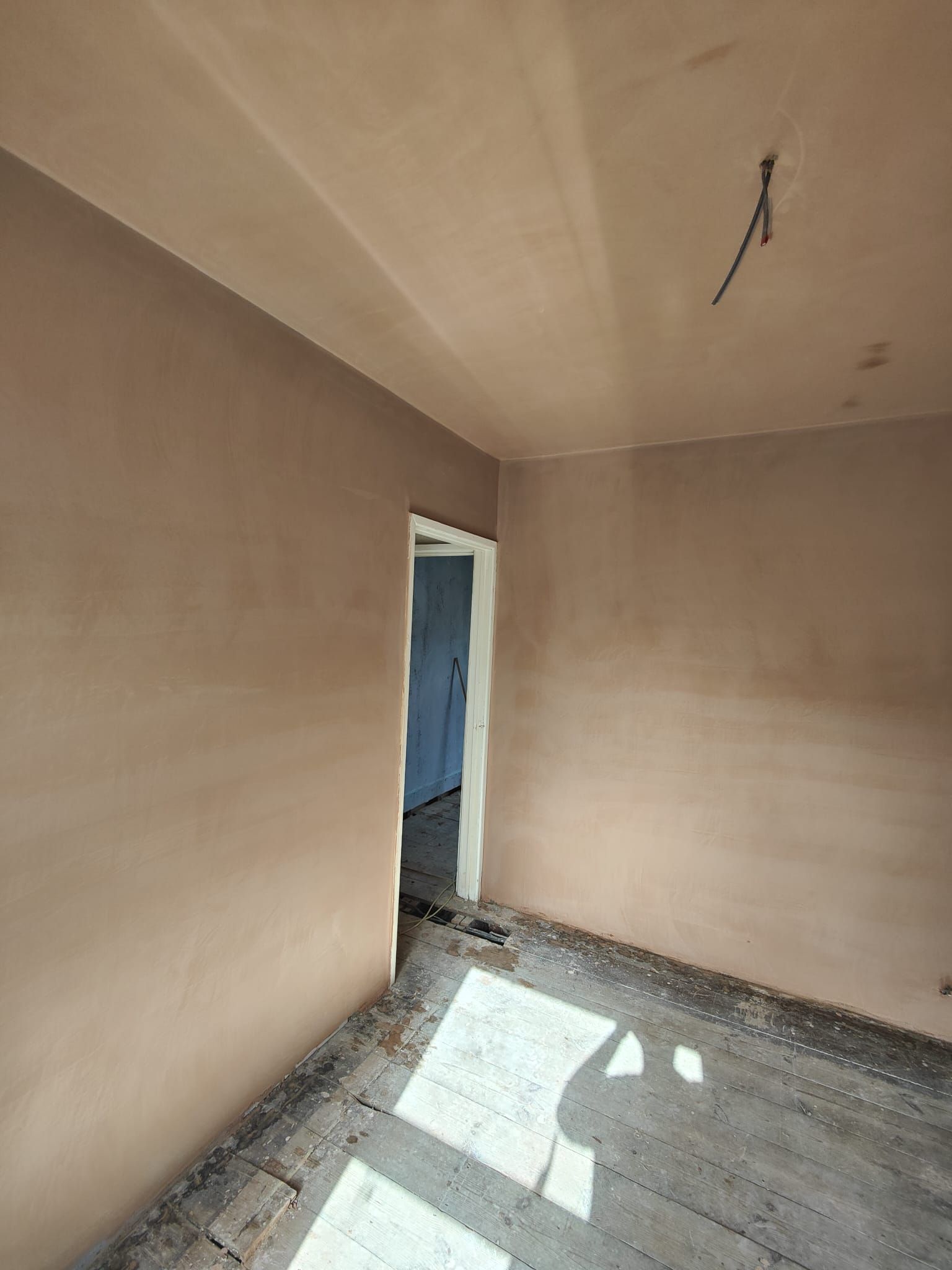 A room with a door and a ceiling that is being remodeled.