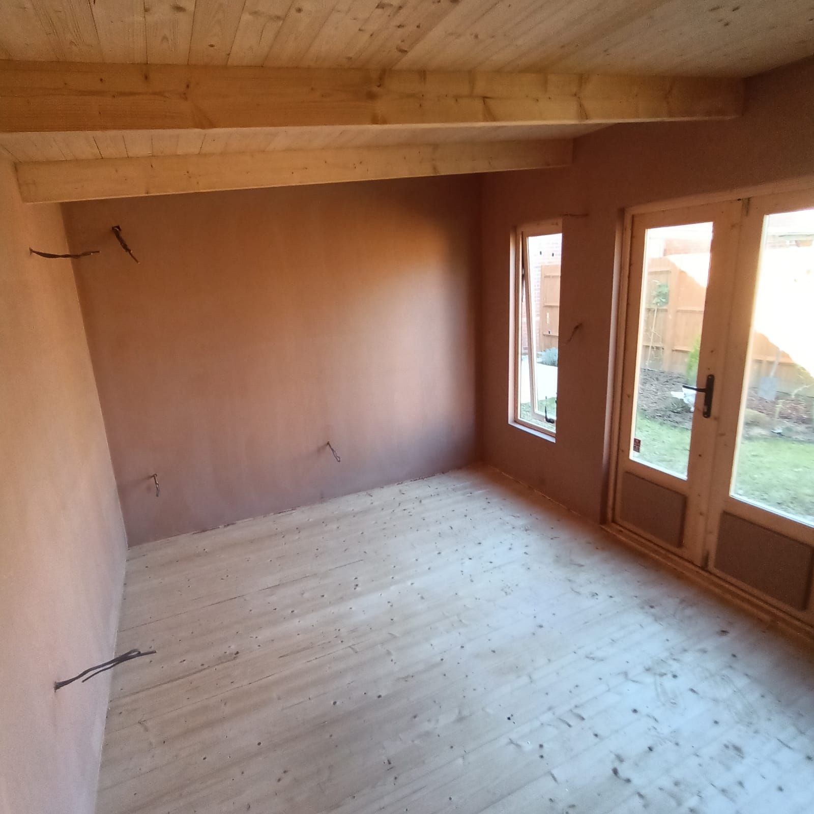 An empty room with wooden floors and a wooden ceiling
