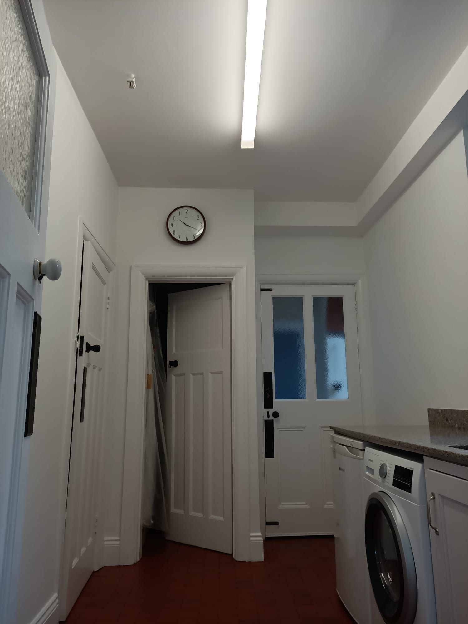 A laundry room with a clock on the wall