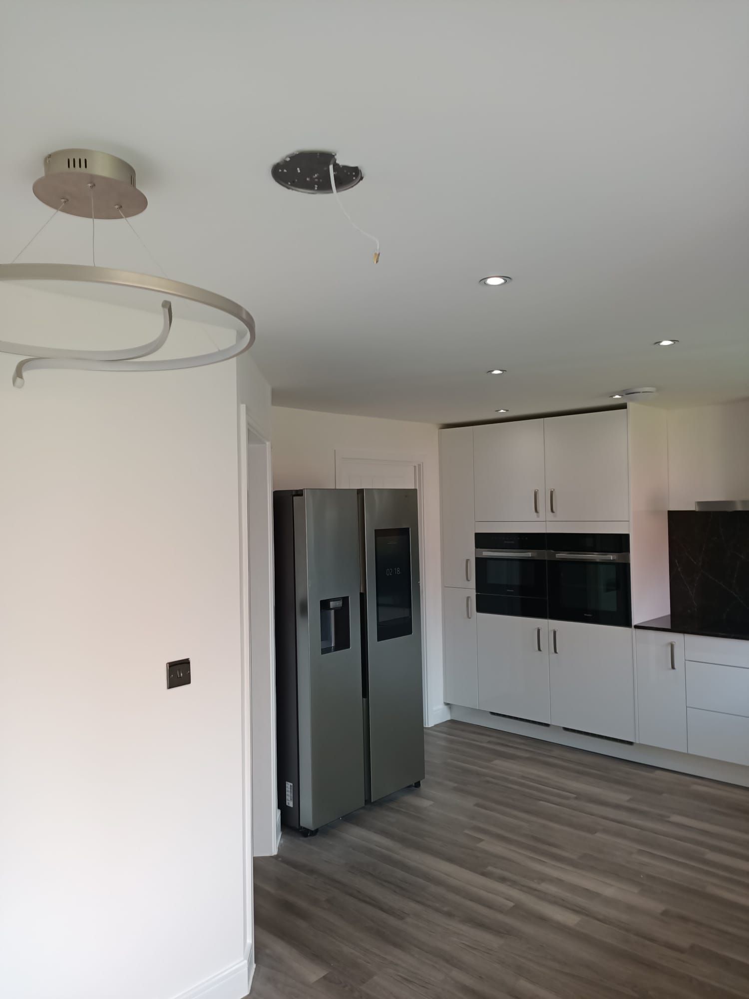 A kitchen with a refrigerator and a microwave