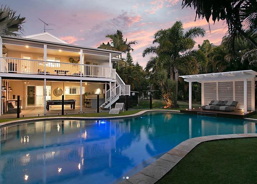 A large house with a swimming pool in front of it