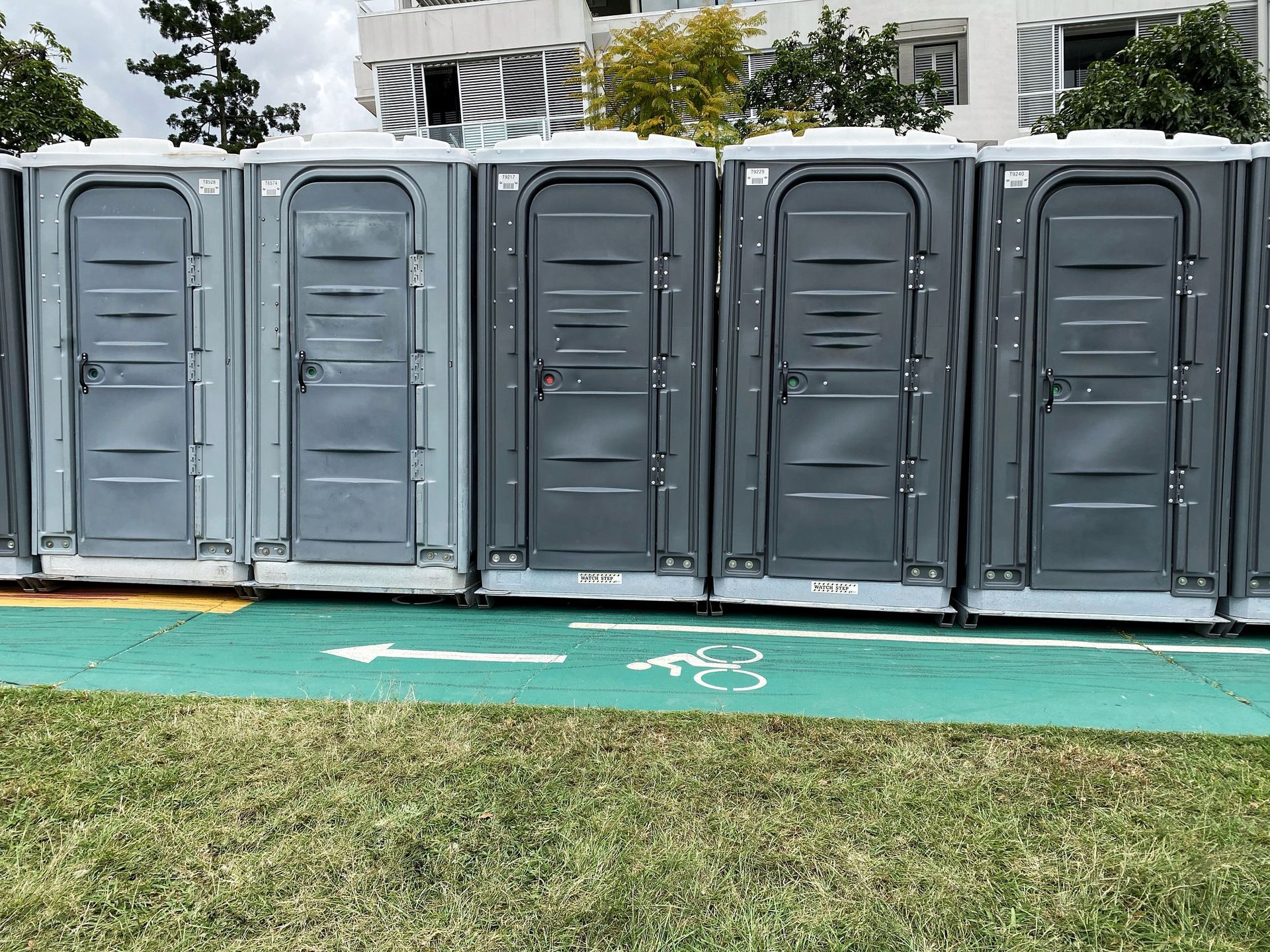 A row of portable toilets outdoors.