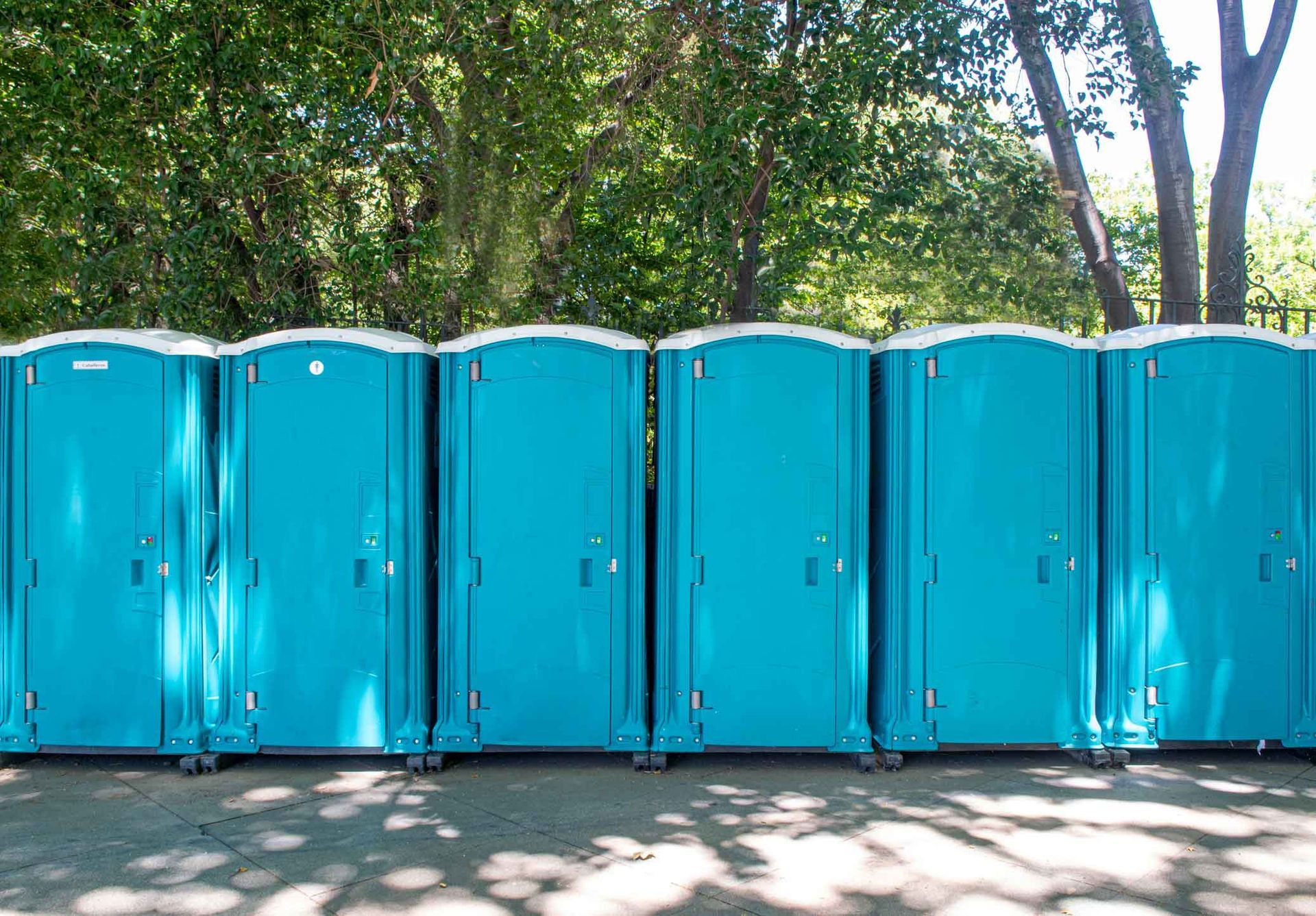 Light blue portable toilets side by side. Light blue portable toilets side by side.