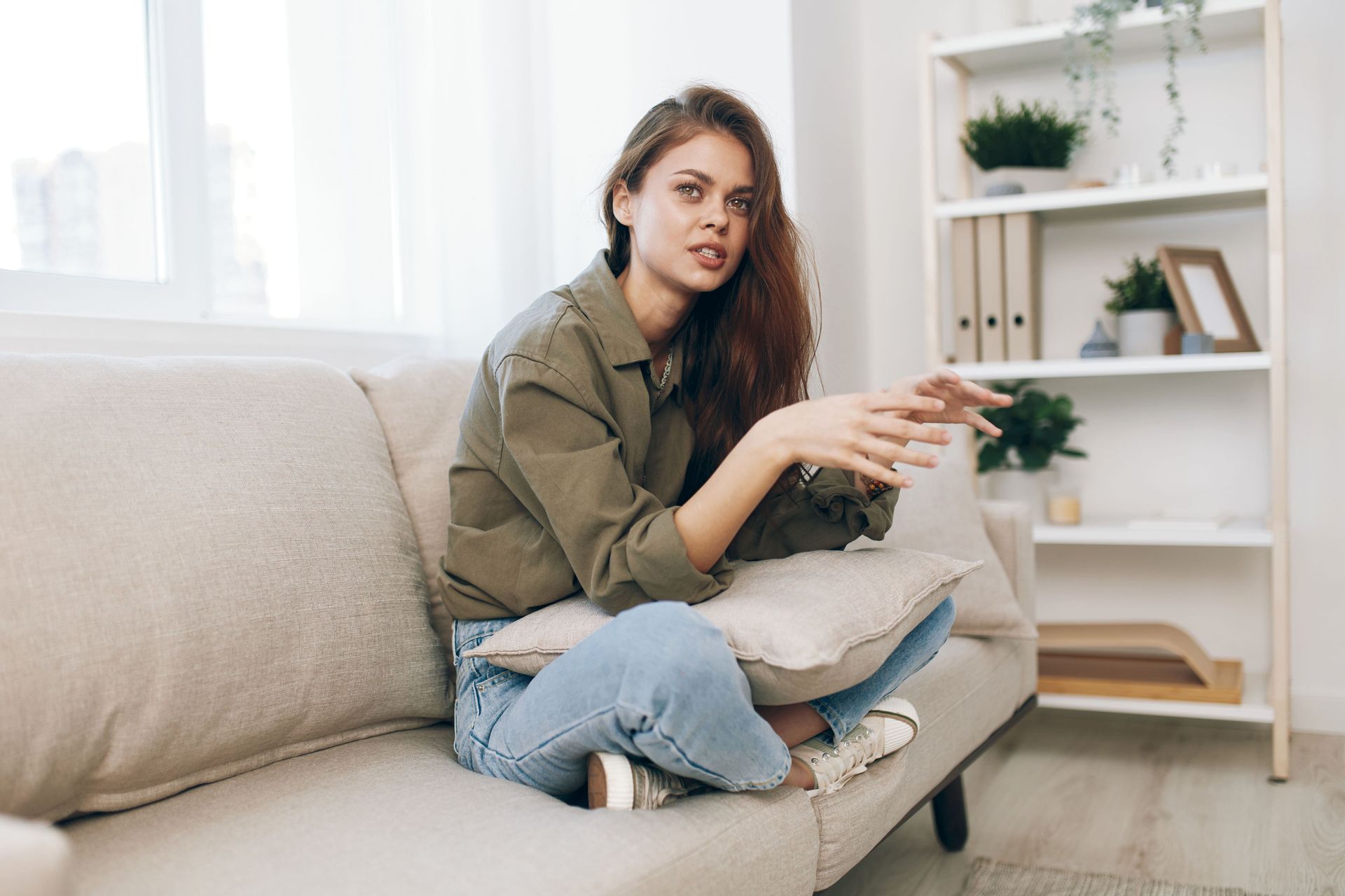 A man and a woman are sitting on a couch talking to a counselor.