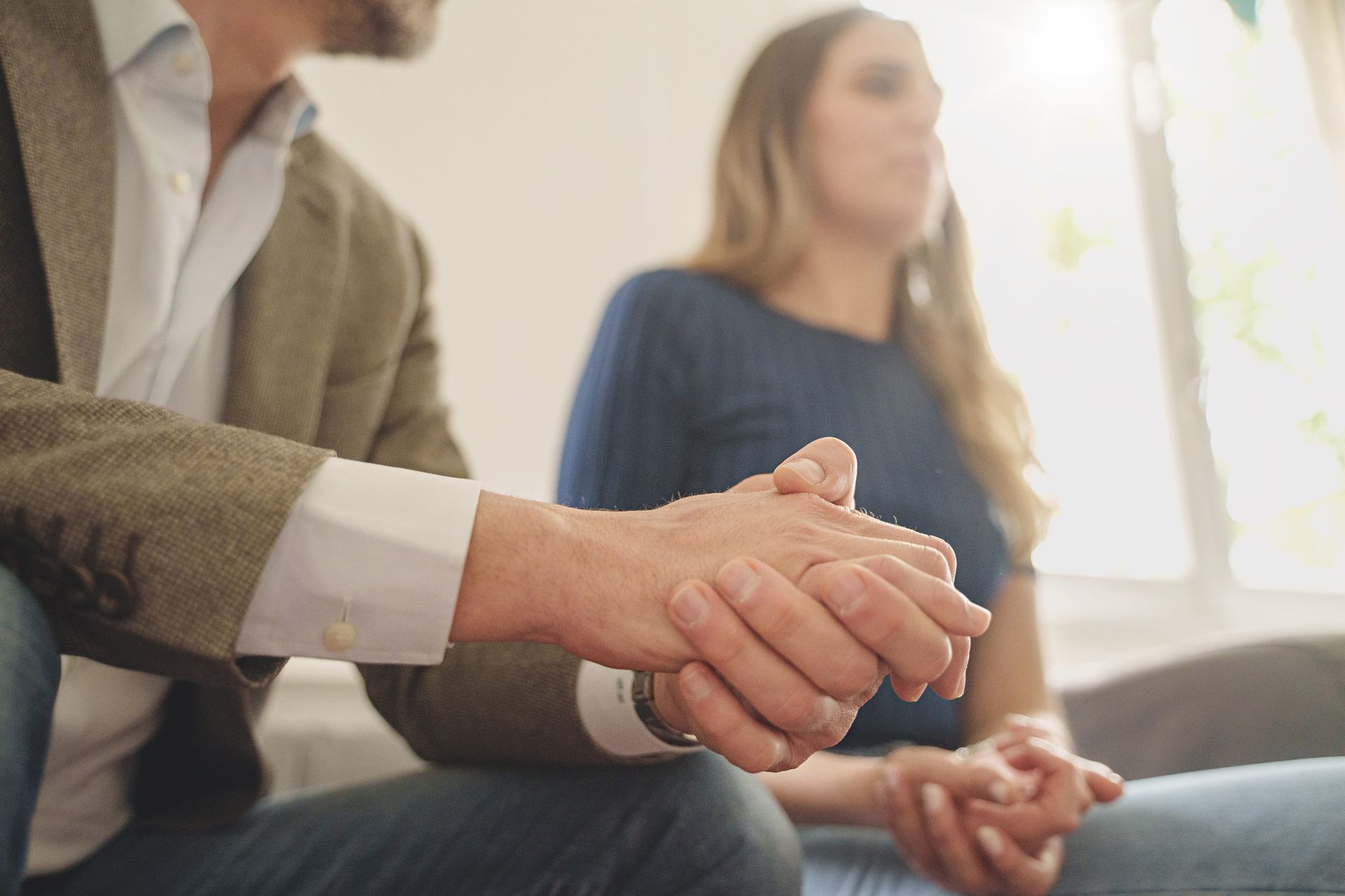 Couple sitting close together working on rebuilding trust after infidelity with a couples therapist
