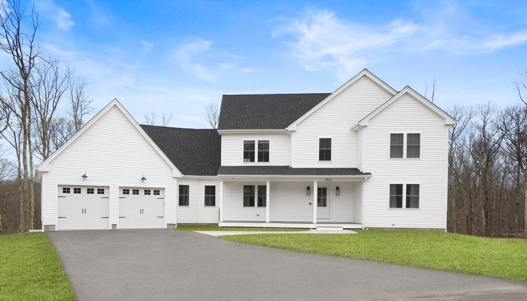 White two-story house with black roof, two-car garage, and a driveway on a sunny day.