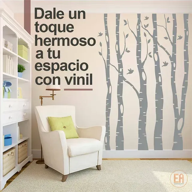 Sala de estar con vinilos decorativos de árboles en la pared y texto en español sobre decoración con vinilo.