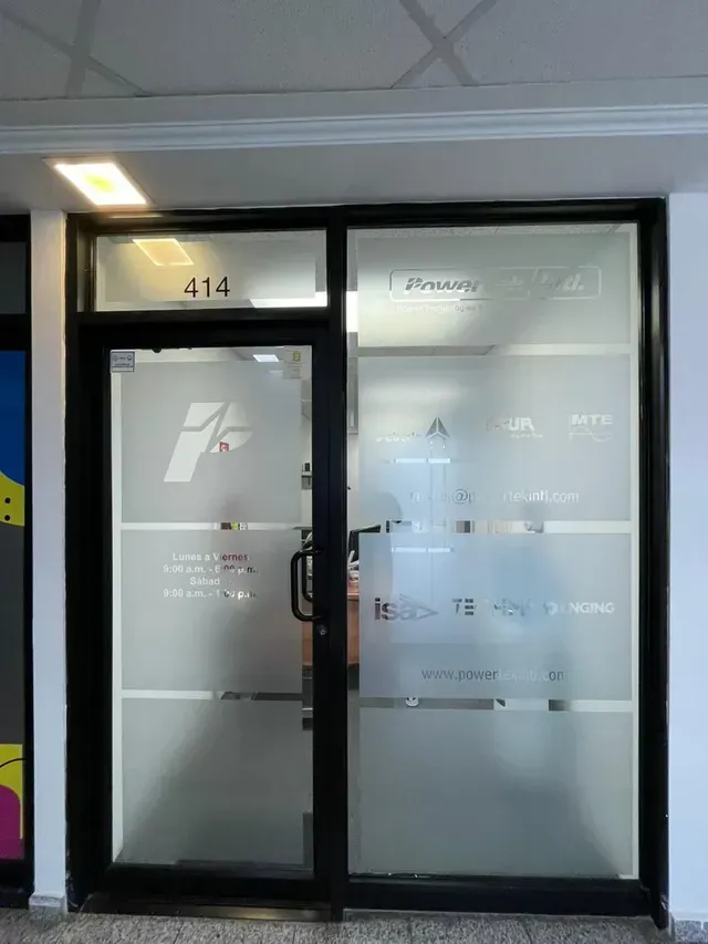 Fachada de cristal con puertas y ventanas esmeriladas, número 414 encima de la puerta izquierda.