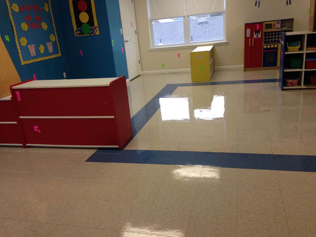 Empty classroom with red and white counter, yellow box, and blue accent stripe on the floor.