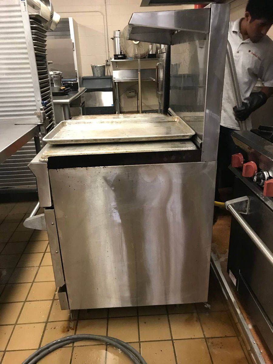 Stainless steel commercial kitchen equipment with a person in the background.