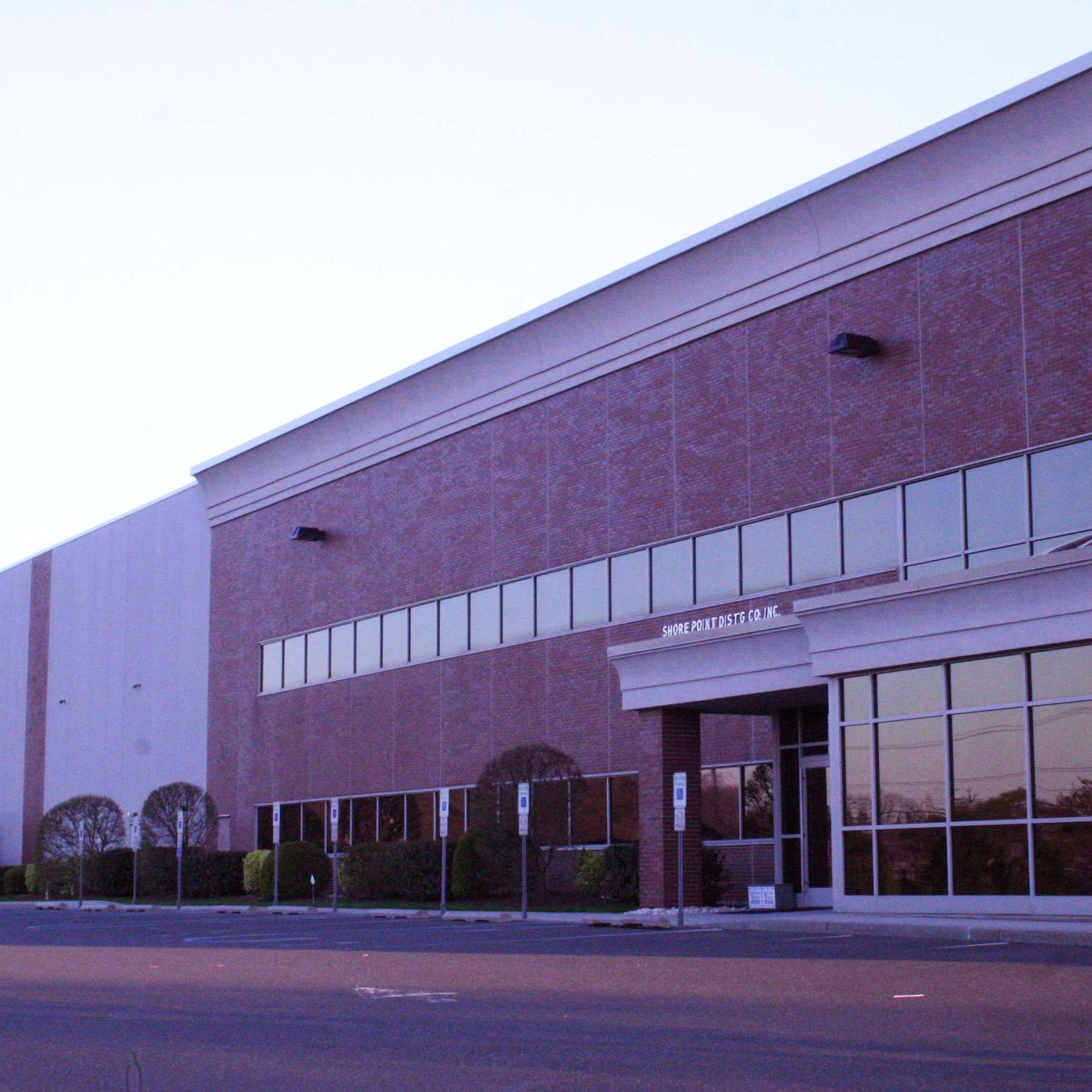 Warehouse building exterior with brick facade and glass windows.