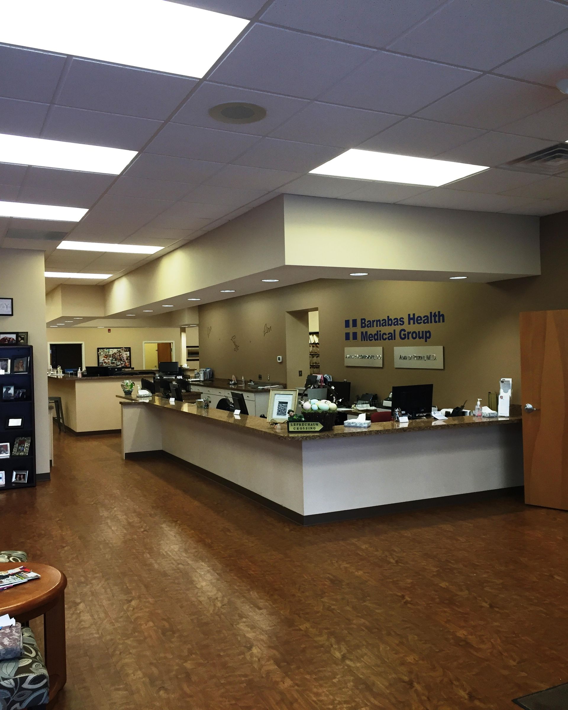 Interior view of a healthcare clinic reception area; desk, waiting area, and signage visible.