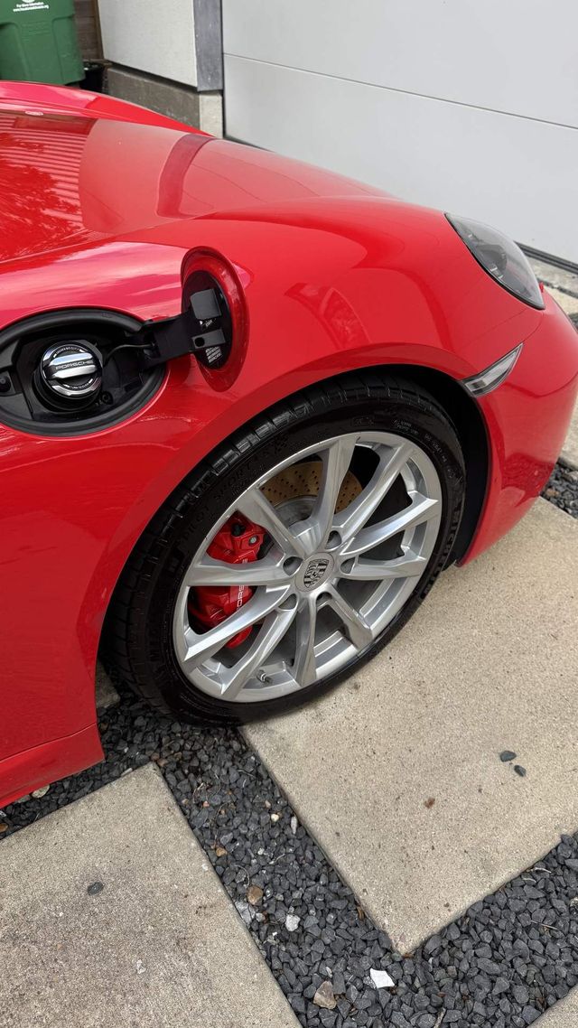 Same Porsche 718 wheel after cleaning, bright silver finish, Ongowash mobile detailing serving Manvel, TX