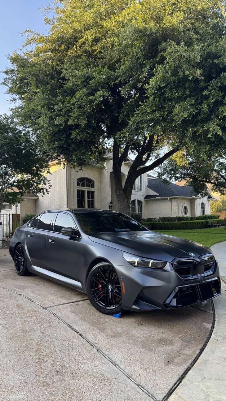 Gray BMW M5 sedan in a driveway after an exterior detail, Ongowash mobile detailing serving Sugar Land, TX