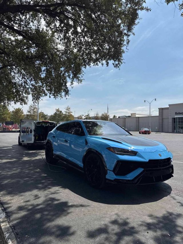 Front view of a blue Lamborghini Urus after a hand wash, Ongowash van in the background, serving Sugar Land, TX