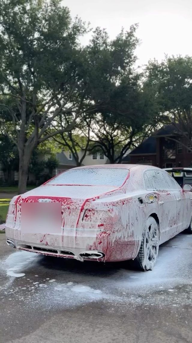 Rolls-Royce Ghost covered in foam with red wheel cleaner running off, Ongowash mobile detailing serving The Woodlands, TX