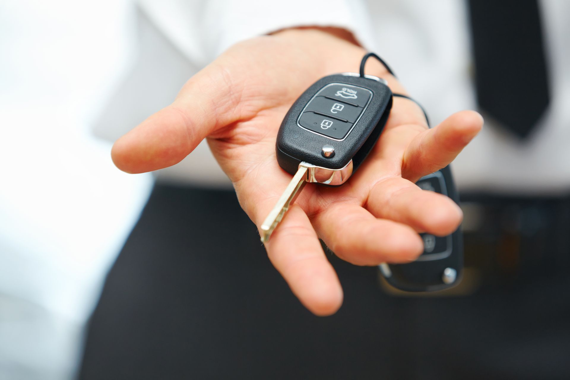 Un homme tient une clé de voiture dans sa main