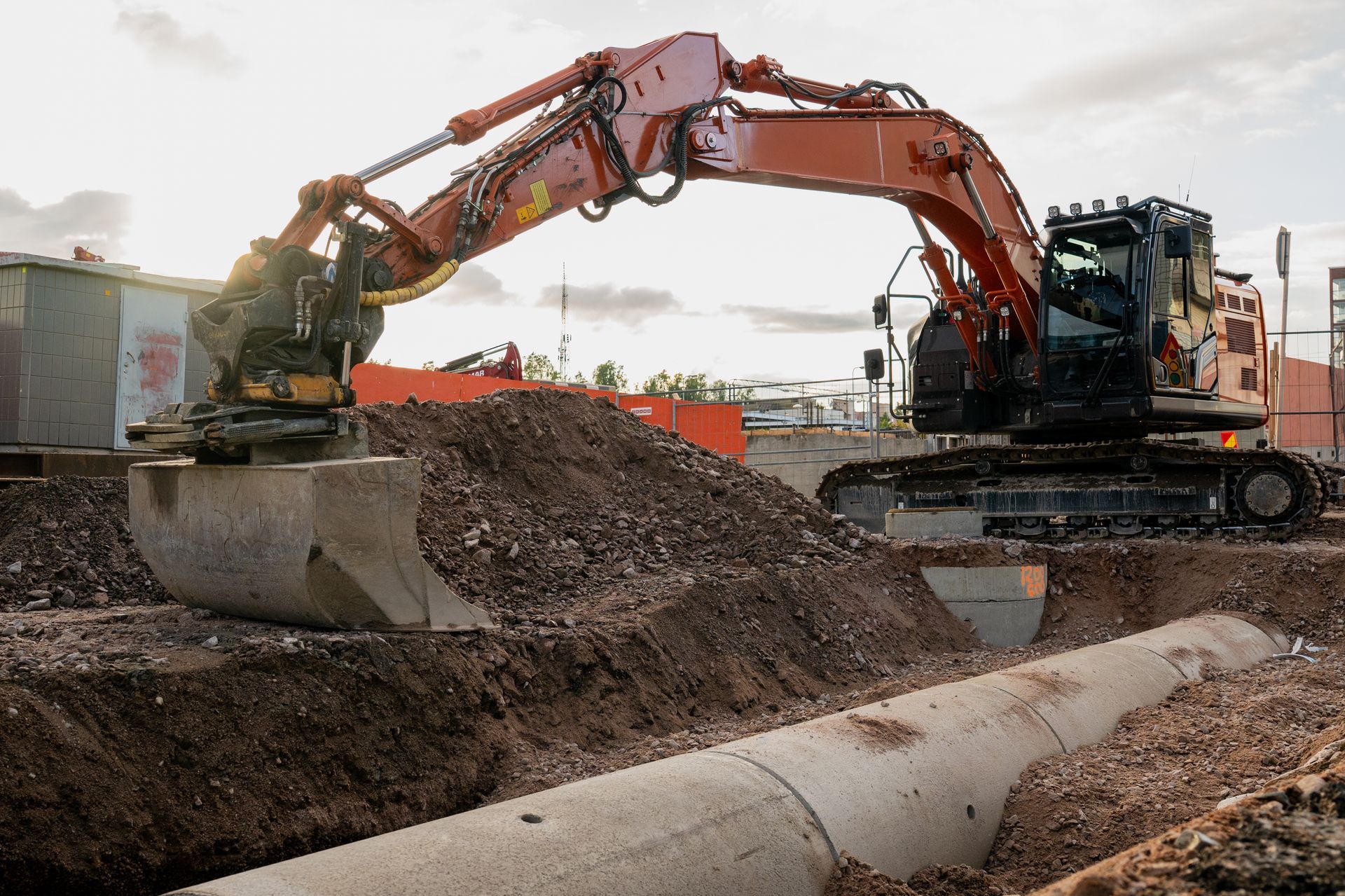 Two excavators digging and loading dirt at a construction site