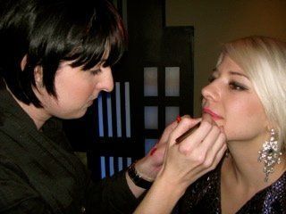 A woman is applying makeup to another woman 's face.
