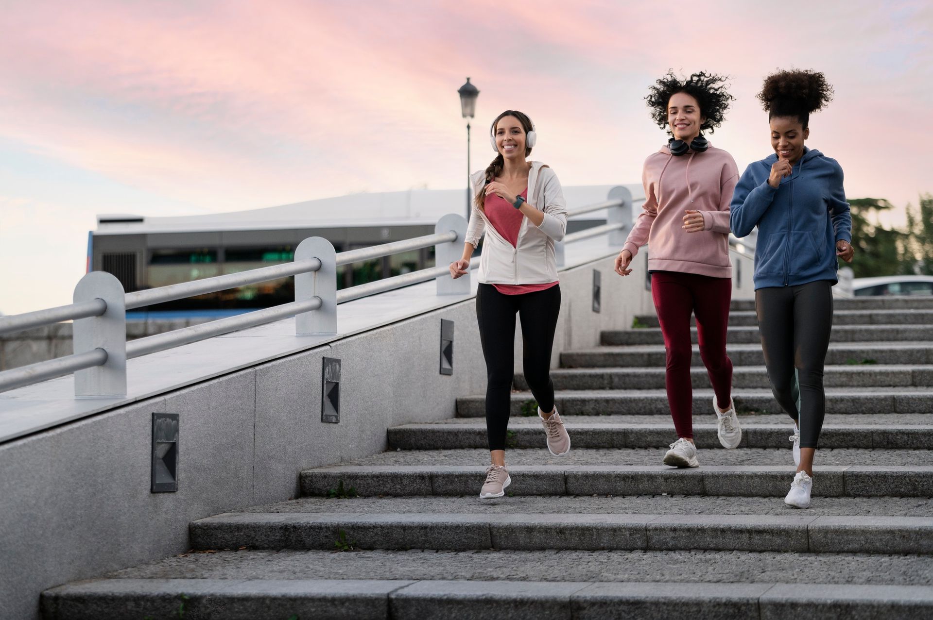 Three women are running up a set of stairs.