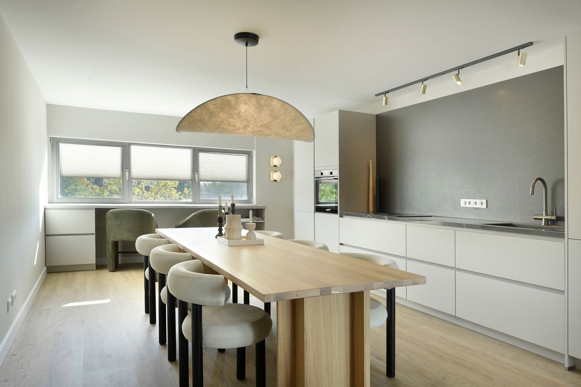 Een keuken met een lange houten tafel en stoelen