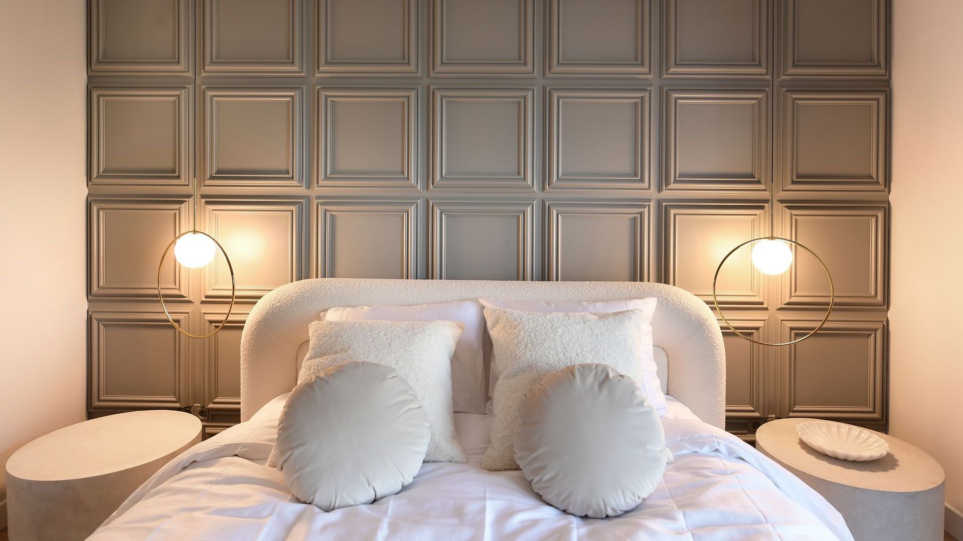 Er staat een bed met witte lakens en kussens in de slaapkamer.