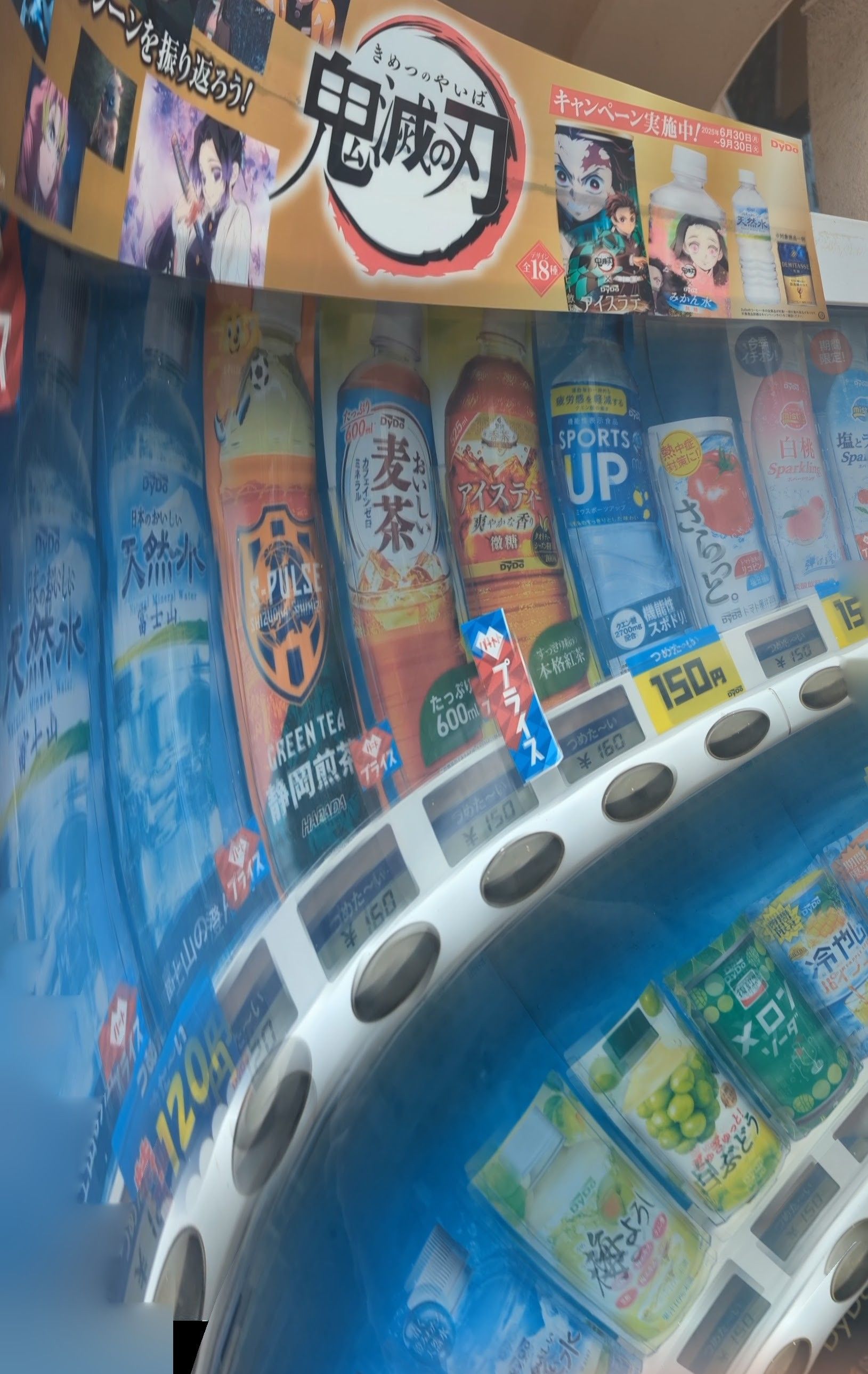 Japanese vending machine with a Demon Slayer anime theme, featuring various colorful beverages.