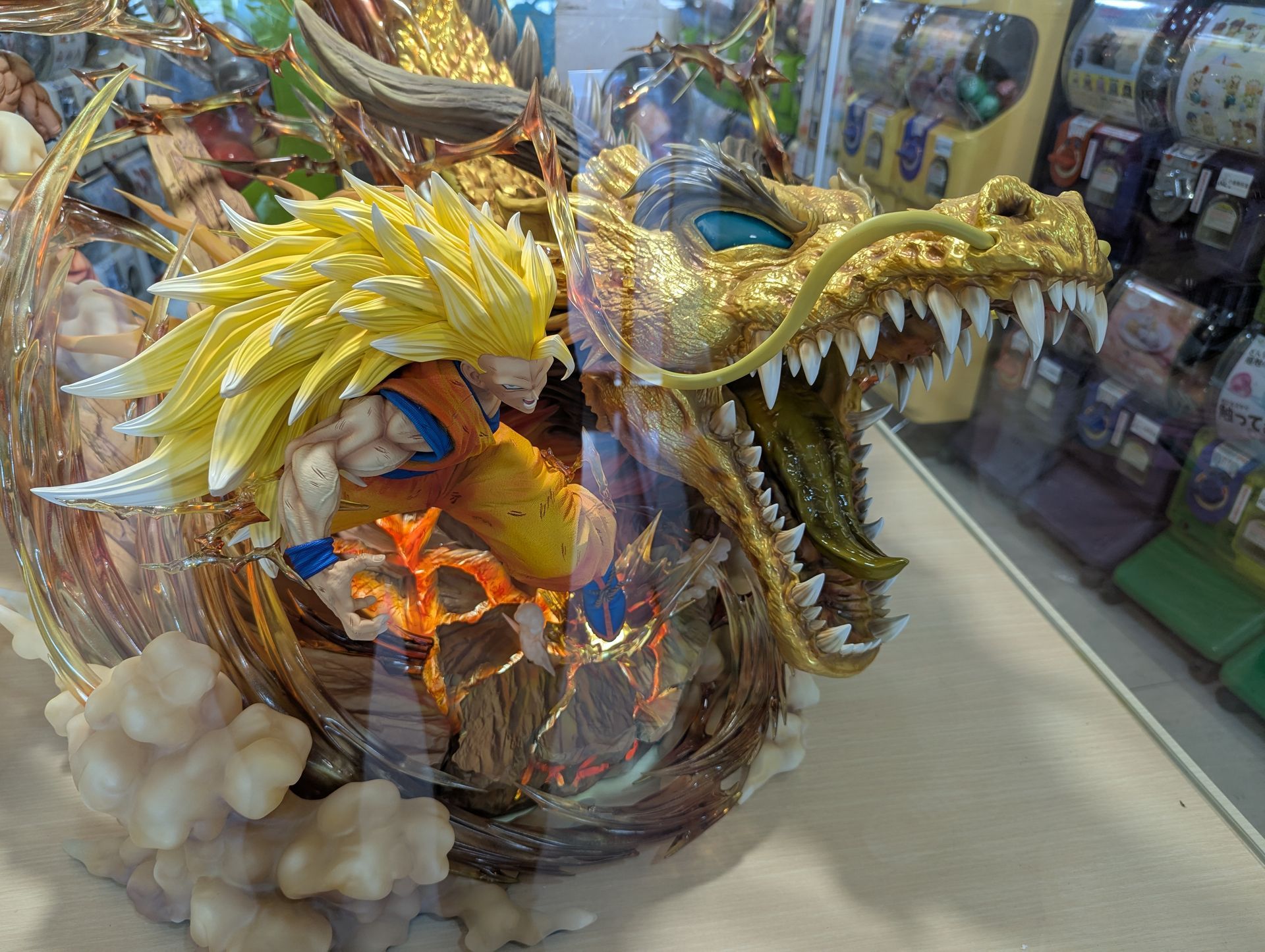 Goku as Super Saiyan 3 inside a golden dragon statue with white clouds in a display case.