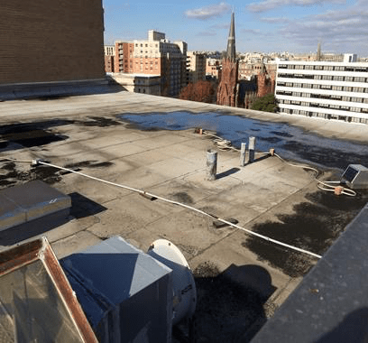 The roof of a building has a lot of water on it