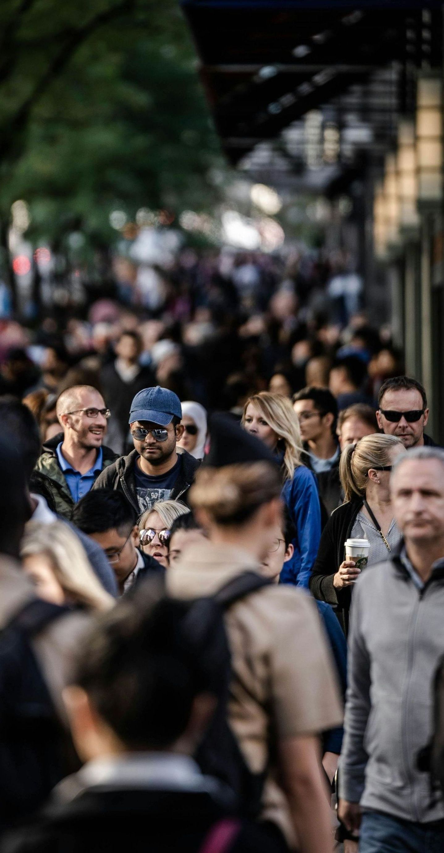 A crowd of people are walking down a street.
