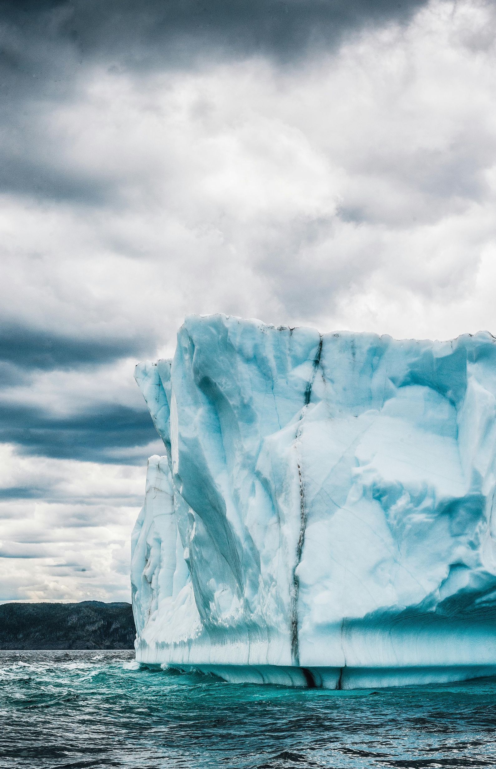 A large iceberg is floating on top of a body of water.
