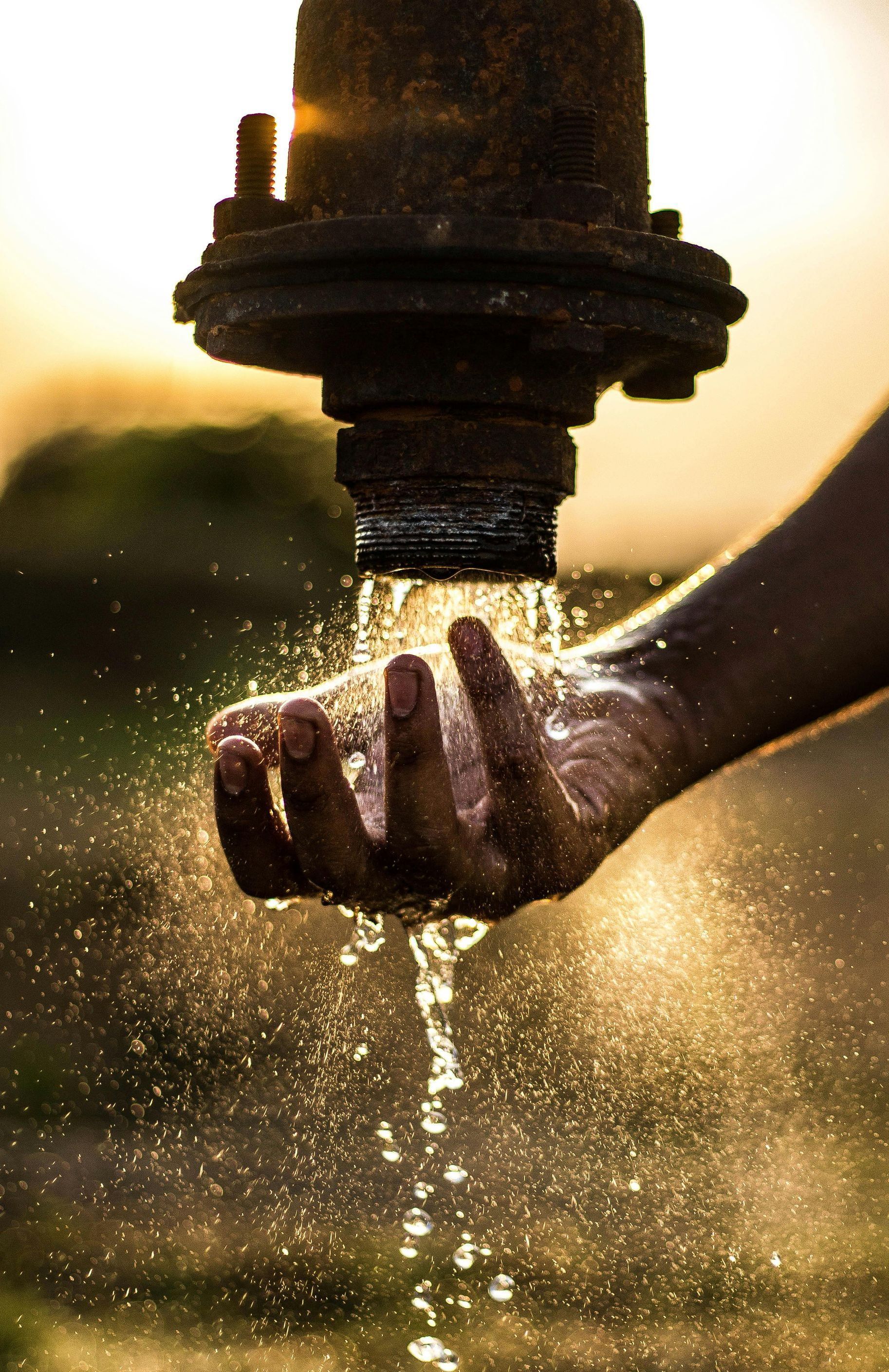 A person is holding a pipe with water coming out of it.