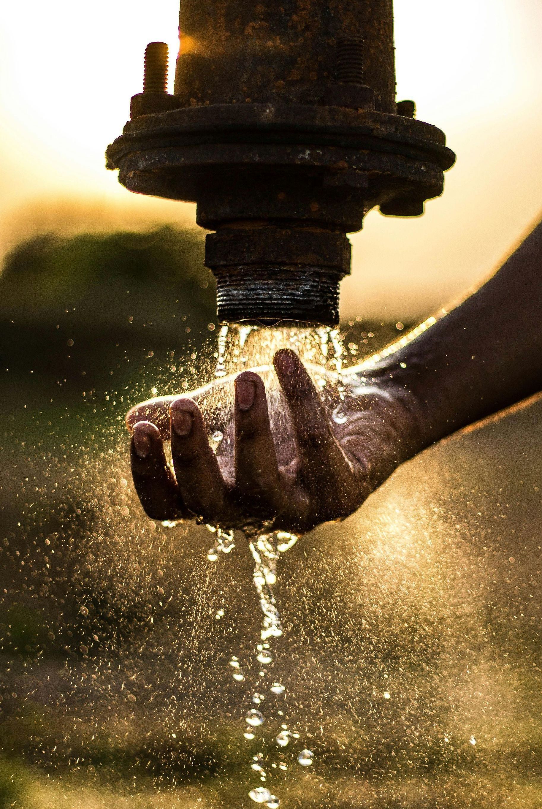 A person is holding a pipe with water coming out of it.