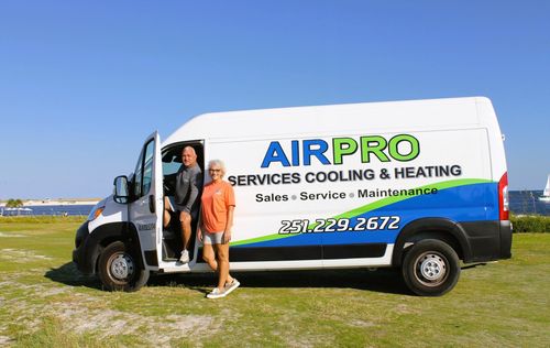 AirPro services van parked on grass with two people standing by the open door