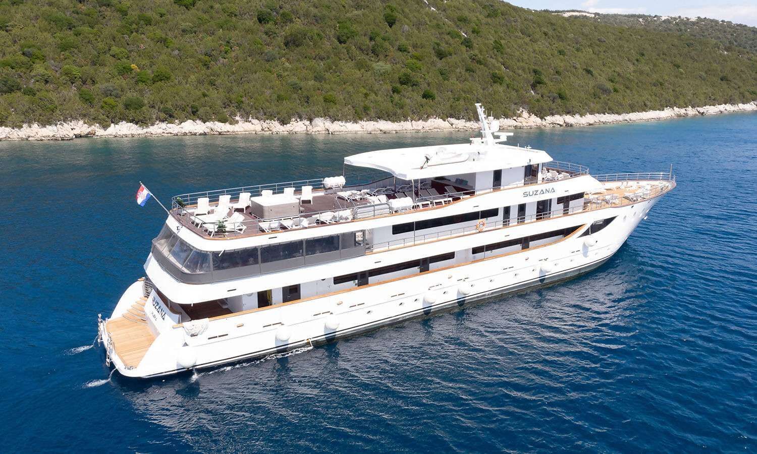 A large white yacht is floating on top of a body of water.