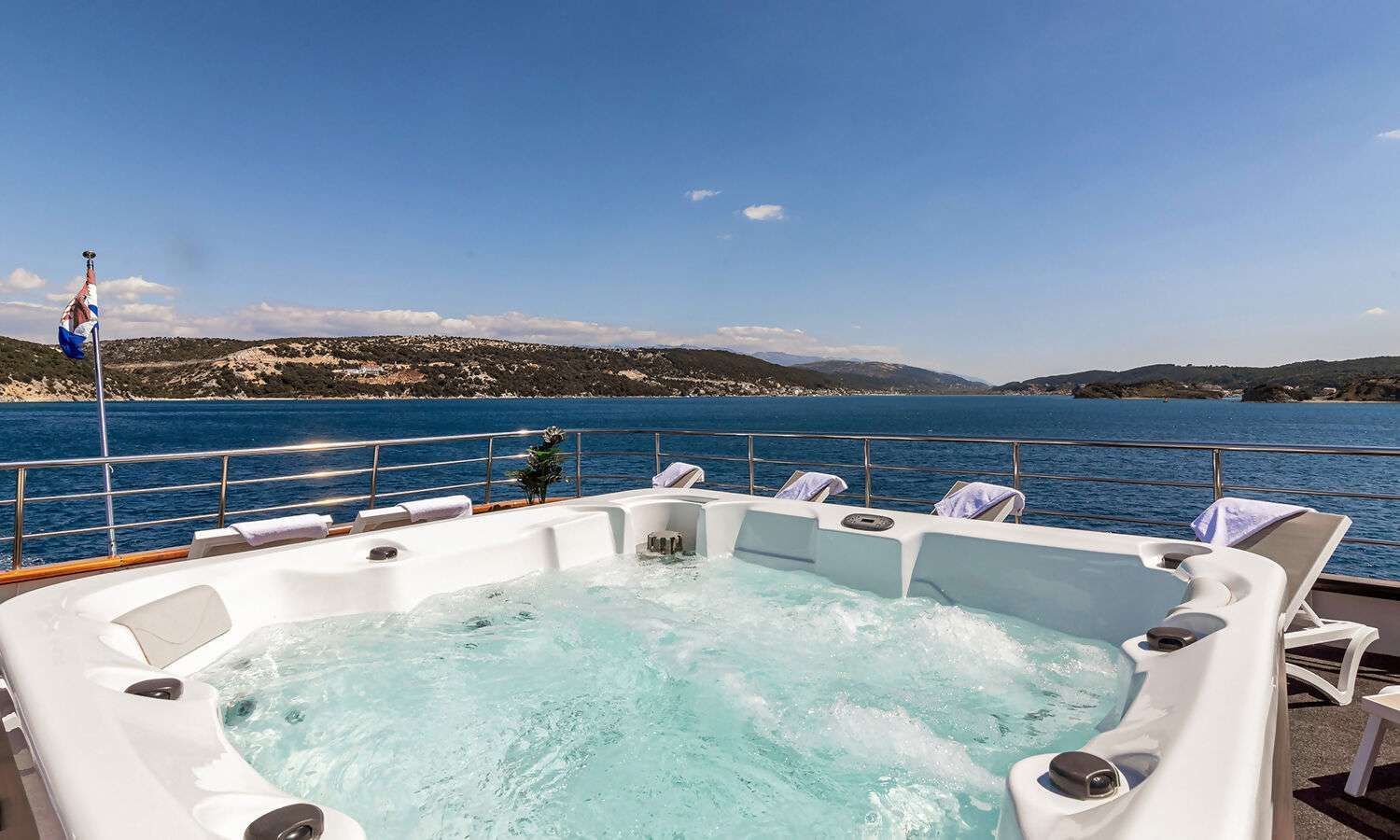 A large jacuzzi on the deck of a boat overlooking the ocean.