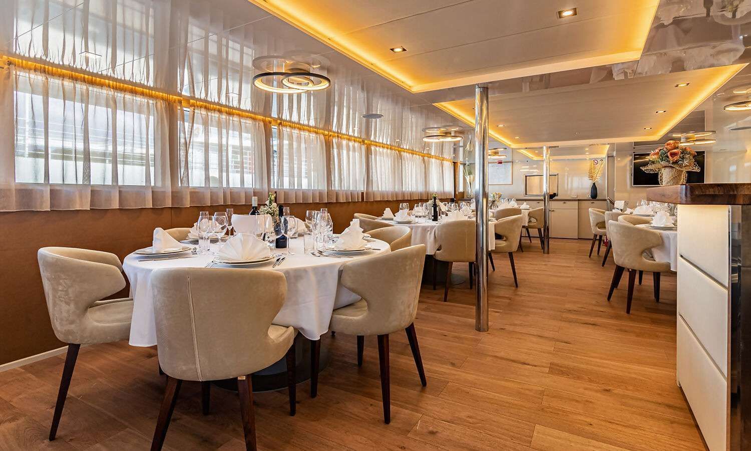A large dining room with tables and chairs and a lot of windows.