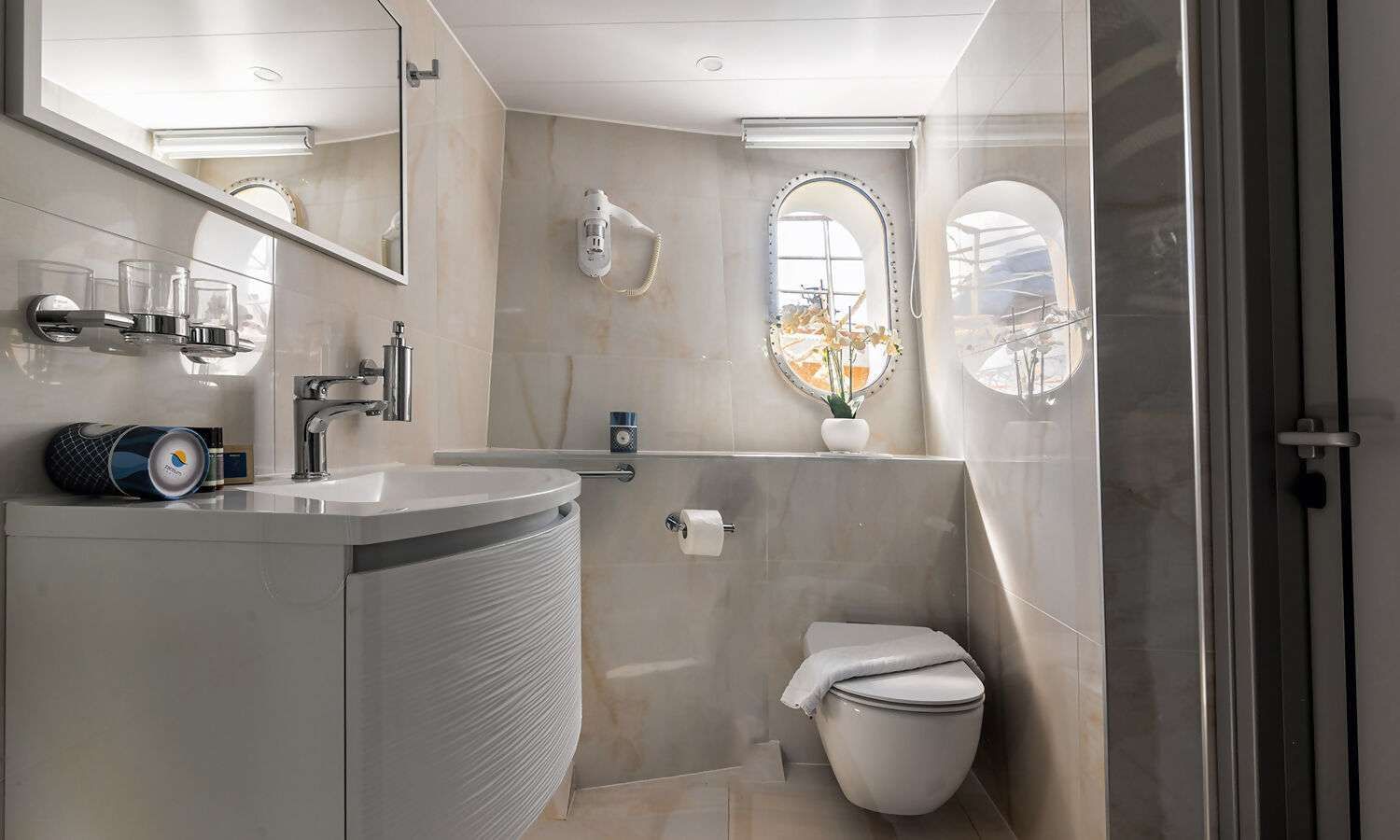 A bathroom with a toilet , sink and mirror.