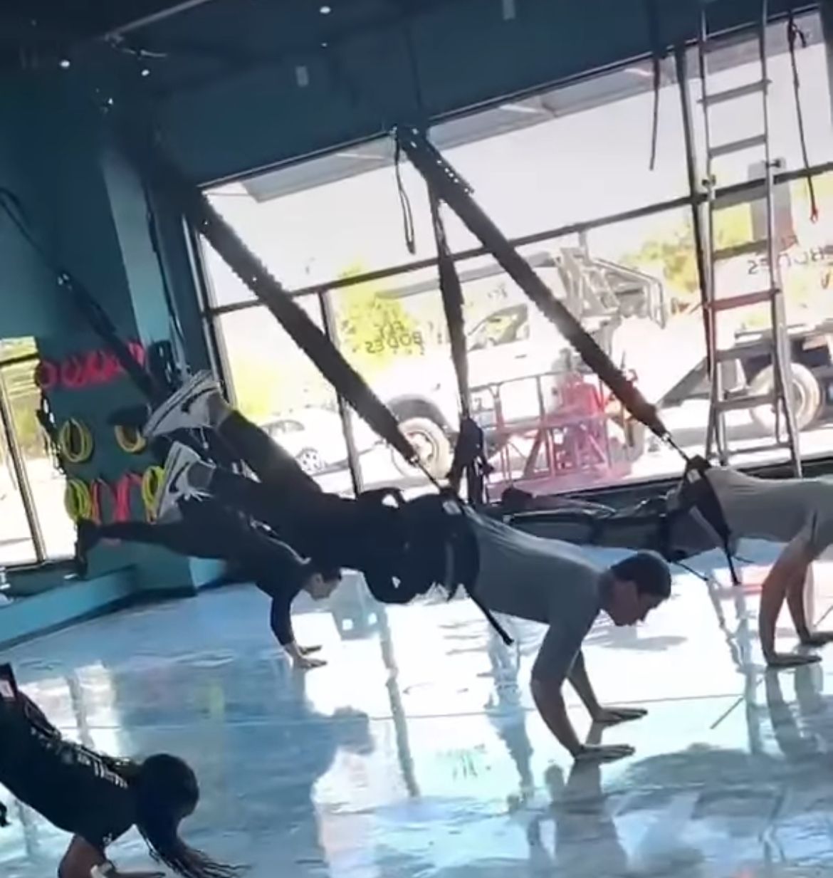 A group of people are doing push ups in a gym.