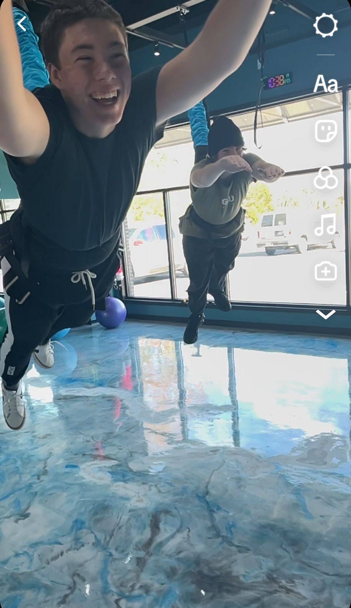 A man is jumping in the air in a gym.