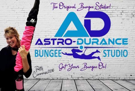 A woman is standing in front of a wall that says astro durance bungee studio