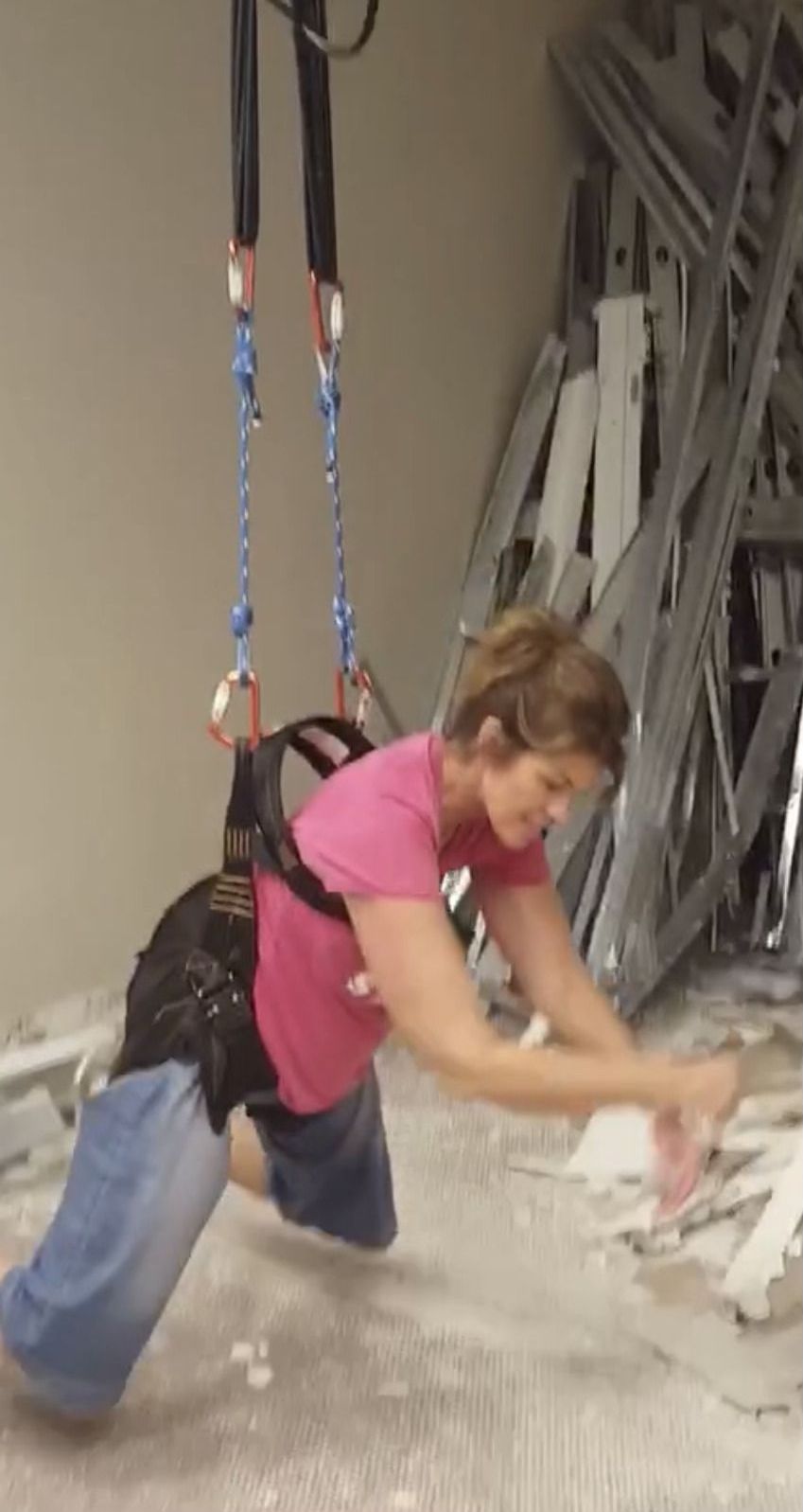A woman in a pink shirt is doing exercises on the floor