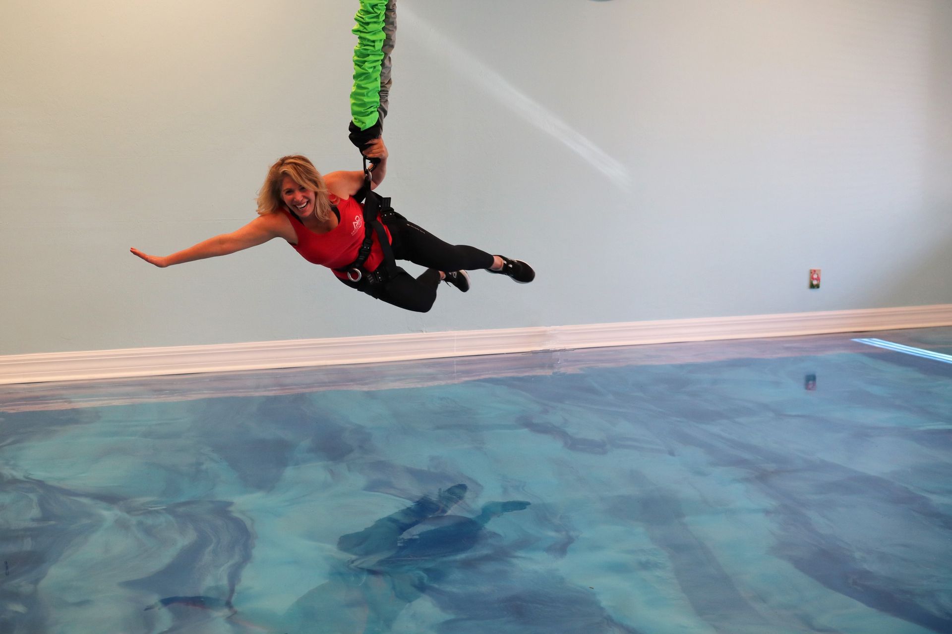 A woman in a red tank top is flying through the air